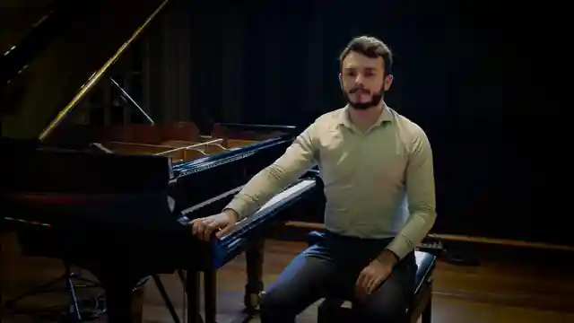 Davi Emerick ao lado de um piano de concerto